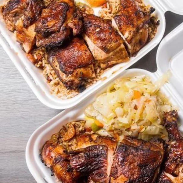 Two takeout containers of Dixon's Jamaican jerk chicken with rice and cabbage.