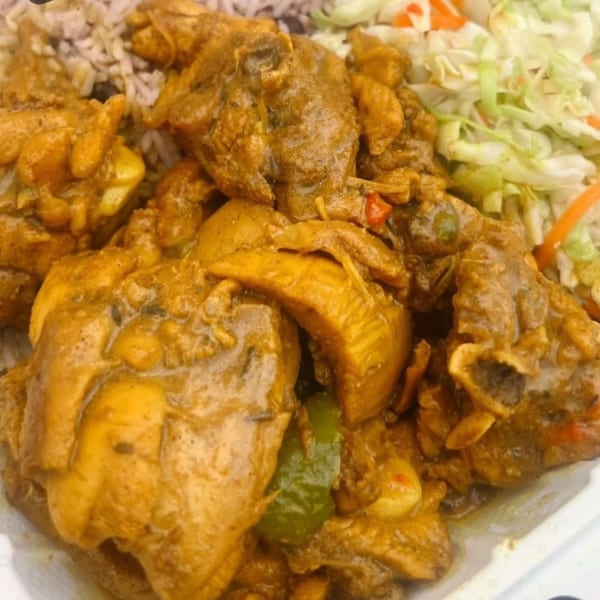 Close-up of Dixon's Jamaican Taste curry chicken with rice and shredded cabbage.