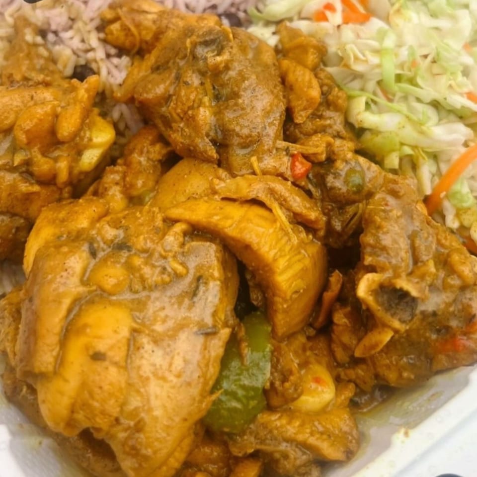 Close-up of Dixon's Jamaican Taste curry chicken with rice and shredded cabbage.