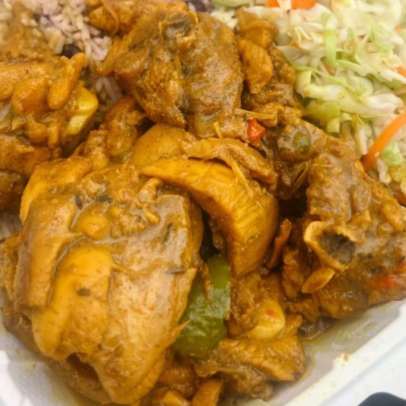 Close-up of Dixon's Jamaican Taste curry chicken with rice and cabbage slaw.